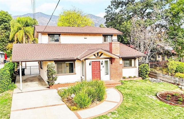 view of front of property featuring a carport, a mountain view, and a front lawn