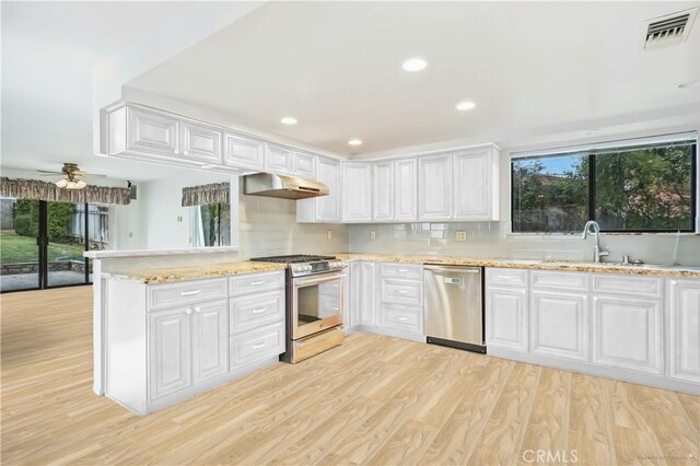 kitchen with white cabinetry, sink, light hardwood / wood-style floors, kitchen peninsula, and stainless steel appliances