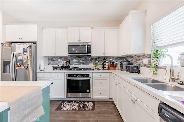 kitchen featuring stainless steel appliances, white cabinetry, dark wood-type flooring, and sink