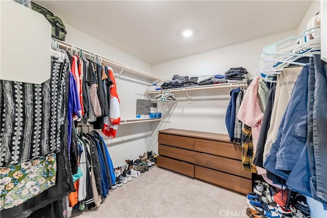 walk in closet featuring light colored carpet