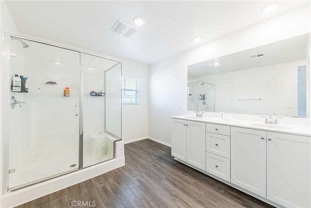 bathroom with hardwood / wood-style flooring, vanity, and walk in shower