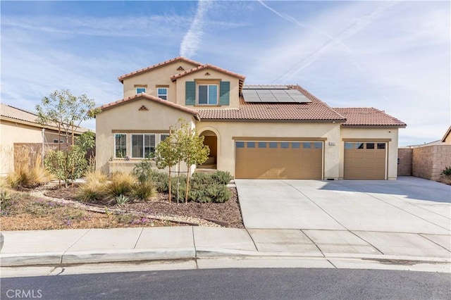 mediterranean / spanish-style home featuring solar panels and a garage