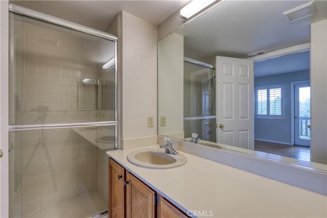 bathroom featuring vanity and a shower with shower door