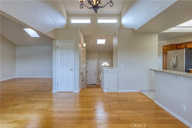 interior space featuring a high ceiling, an inviting chandelier, and light hardwood / wood-style flooring