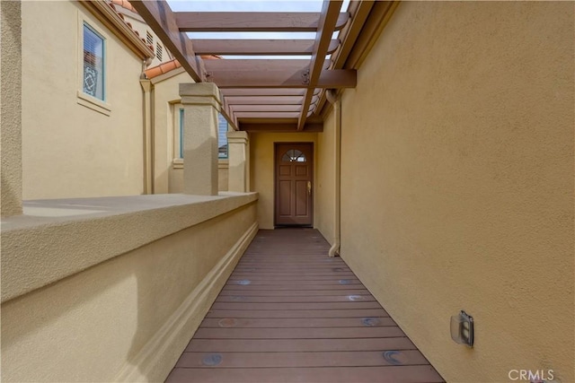 property entrance with a balcony and a pergola