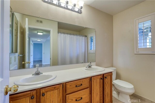 bathroom with tile patterned floors, vanity, and toilet