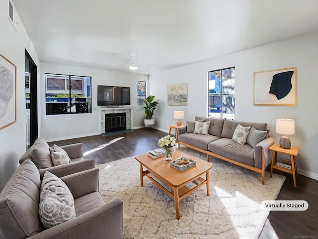 living room featuring ceiling fan and dark hardwood / wood-style flooring