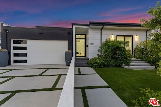 modern home featuring a yard and a garage