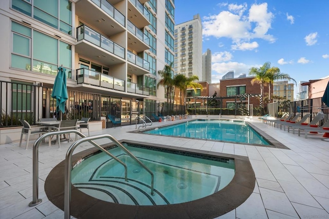 view of pool with a community hot tub and a patio