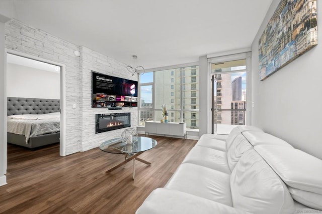 living room featuring hardwood / wood-style floors, a wall of windows, and a fireplace