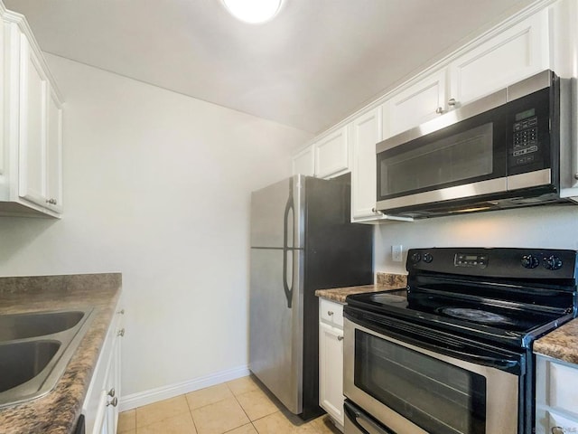 kitchen with light tile patterned flooring, white cabinetry, sink, and appliances with stainless steel finishes