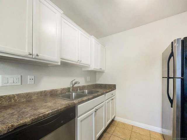 kitchen featuring light tile patterned flooring, stainless steel appliances, white cabinetry, and sink