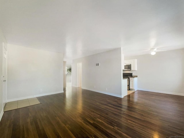 unfurnished living room featuring ceiling fan and dark wood-type flooring