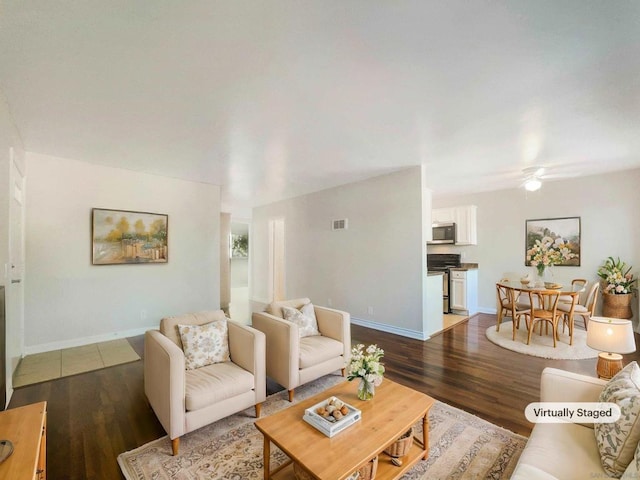 living room with ceiling fan and dark hardwood / wood-style flooring