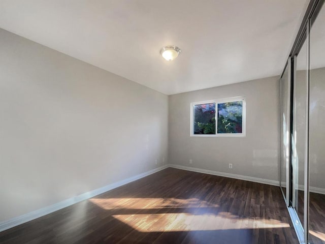 unfurnished bedroom featuring a closet and dark hardwood / wood-style flooring