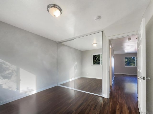 unfurnished bedroom featuring a closet and dark hardwood / wood-style floors