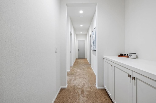 hall featuring light colored carpet