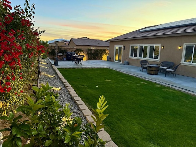 yard at dusk featuring a patio