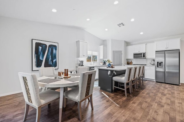 dining room with lofted ceiling, dark wood-type flooring, and sink