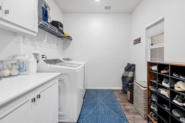 washroom featuring cabinets, dark hardwood / wood-style flooring, and washing machine and clothes dryer