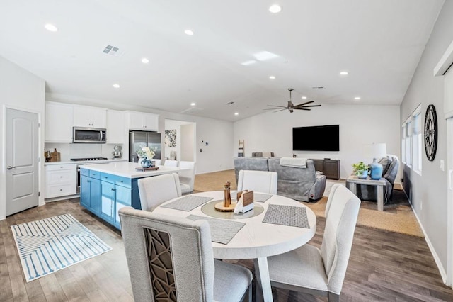 dining space with hardwood / wood-style floors, ceiling fan, and lofted ceiling