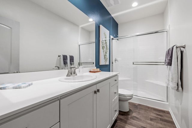 bathroom with vanity, hardwood / wood-style flooring, toilet, and a shower with shower door