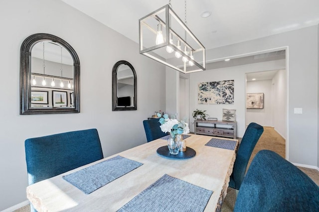 dining area with carpet floors and a notable chandelier