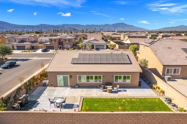 rear view of property with a mountain view, solar panels, a patio area, and central air condition unit