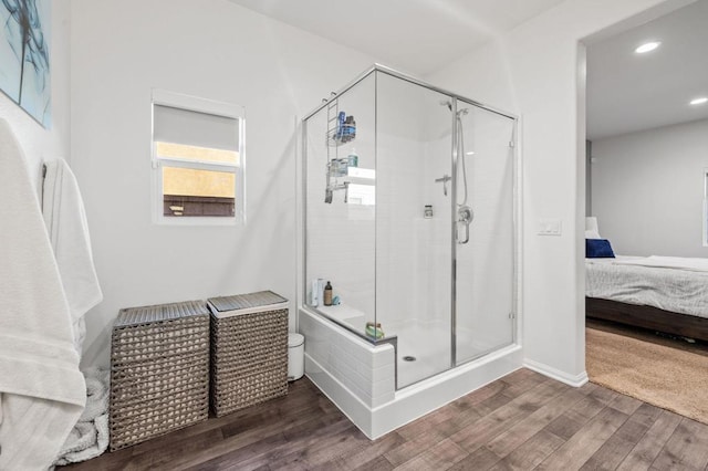 bathroom with wood-type flooring and an enclosed shower