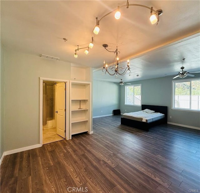 unfurnished bedroom featuring multiple windows, dark wood-type flooring, and a notable chandelier