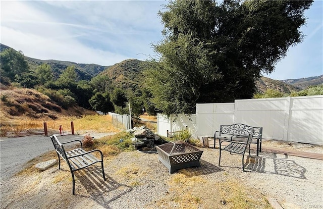 view of patio / terrace with a mountain view and an outdoor fire pit