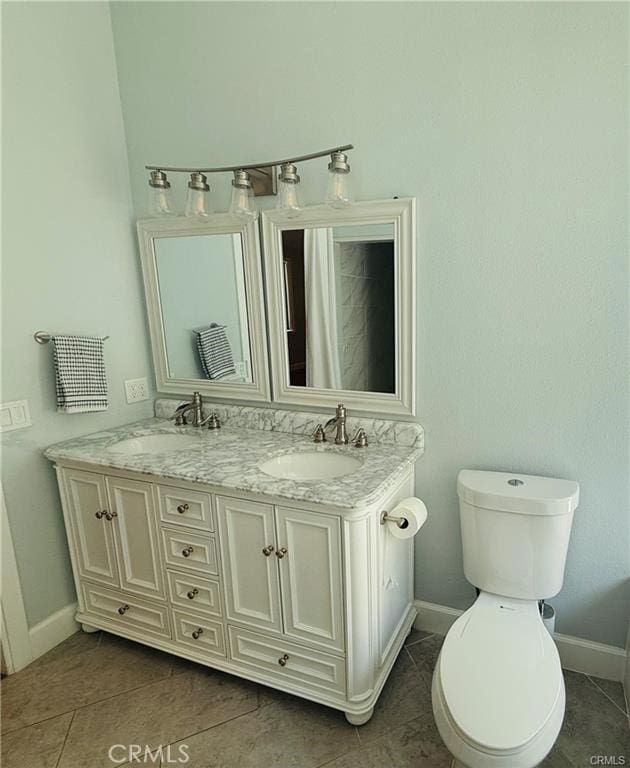 bathroom with tile patterned flooring, vanity, and toilet