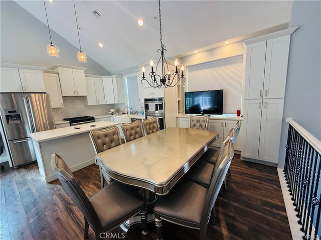 dining room with dark hardwood / wood-style flooring, high vaulted ceiling, an inviting chandelier, and sink