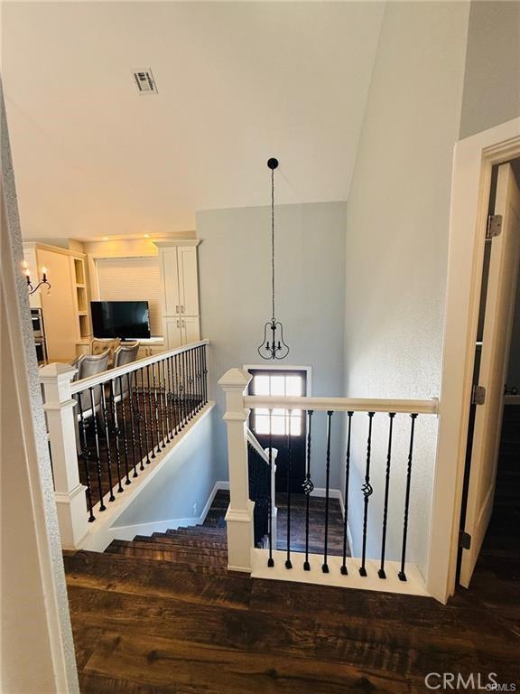 stairway featuring hardwood / wood-style floors and high vaulted ceiling