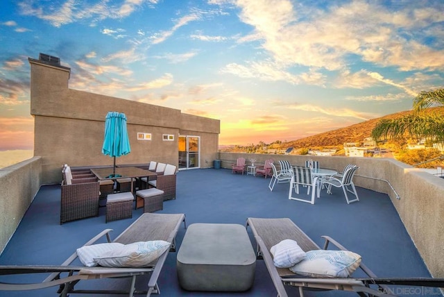 patio terrace at dusk featuring a balcony