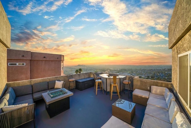 patio terrace at dusk with an outdoor living space with a fire pit