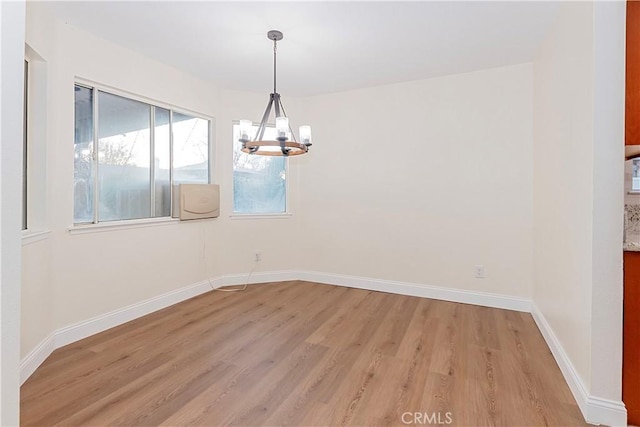 unfurnished dining area featuring a notable chandelier and light hardwood / wood-style flooring