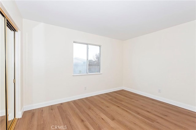 unfurnished bedroom featuring a closet and light wood-type flooring