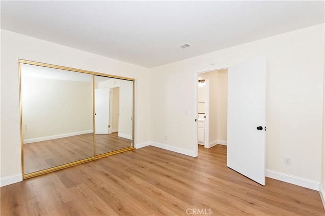 unfurnished bedroom featuring light hardwood / wood-style flooring and a closet