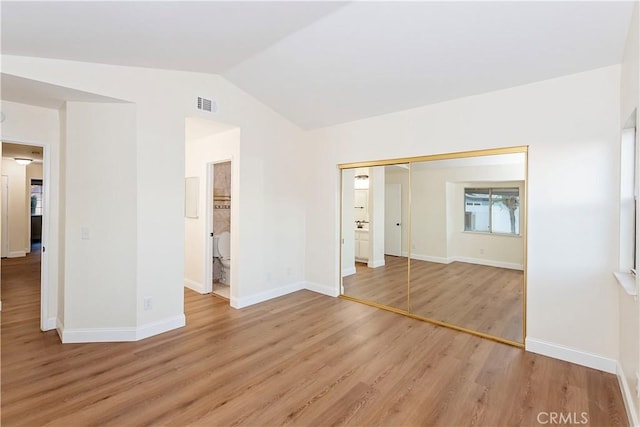 unfurnished room with light hardwood / wood-style floors and lofted ceiling