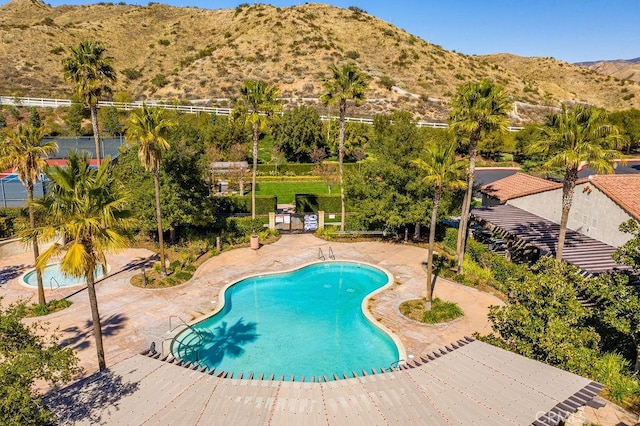 view of pool featuring a mountain view and a patio area