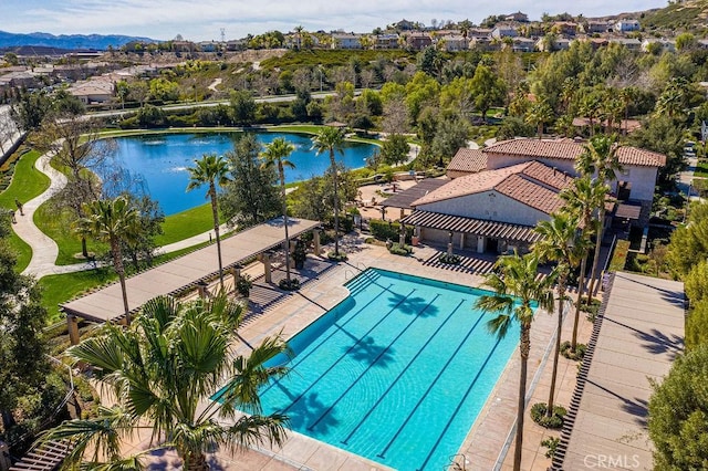 view of pool featuring a patio area and a water view