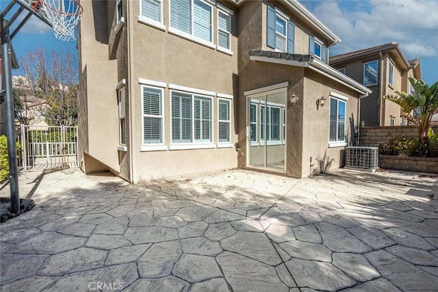 back of property with central AC unit and a patio area