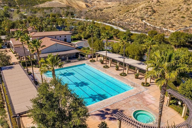 view of swimming pool with a patio area and a hot tub