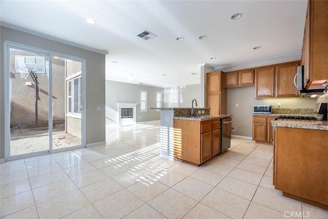 kitchen featuring a kitchen island with sink, crown molding, sink, and appliances with stainless steel finishes