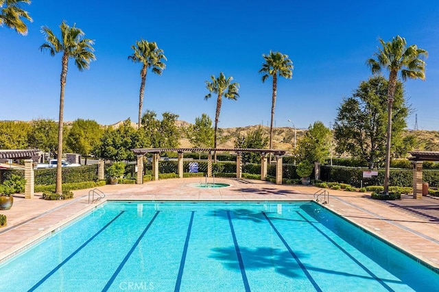 view of swimming pool featuring a pergola, a patio, and a hot tub