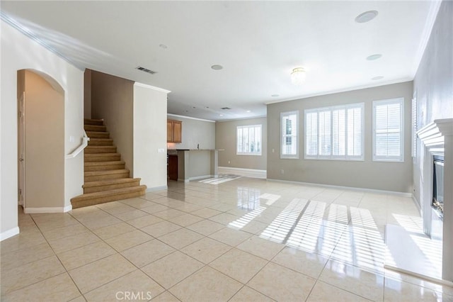 unfurnished living room with crown molding and light tile patterned floors