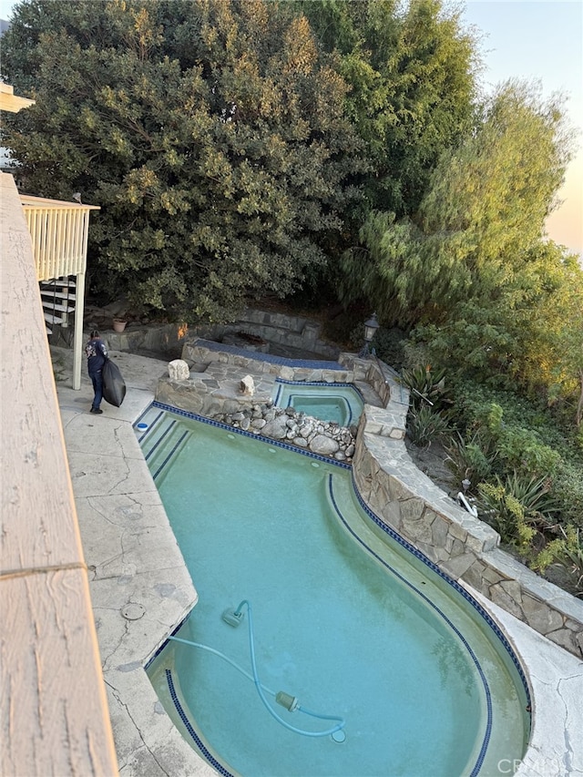 view of swimming pool featuring an in ground hot tub