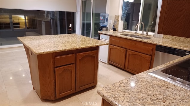 kitchen featuring light stone counters, stainless steel dishwasher, sink, light tile patterned floors, and a kitchen island