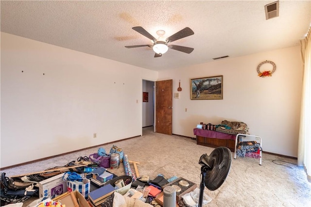 interior space featuring a textured ceiling, ceiling fan, and light carpet